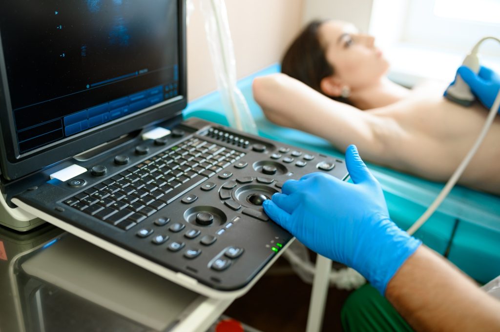 A mammologist makes breast ultrasound scanning