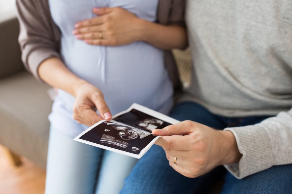 close up of couple with baby ultrasound images